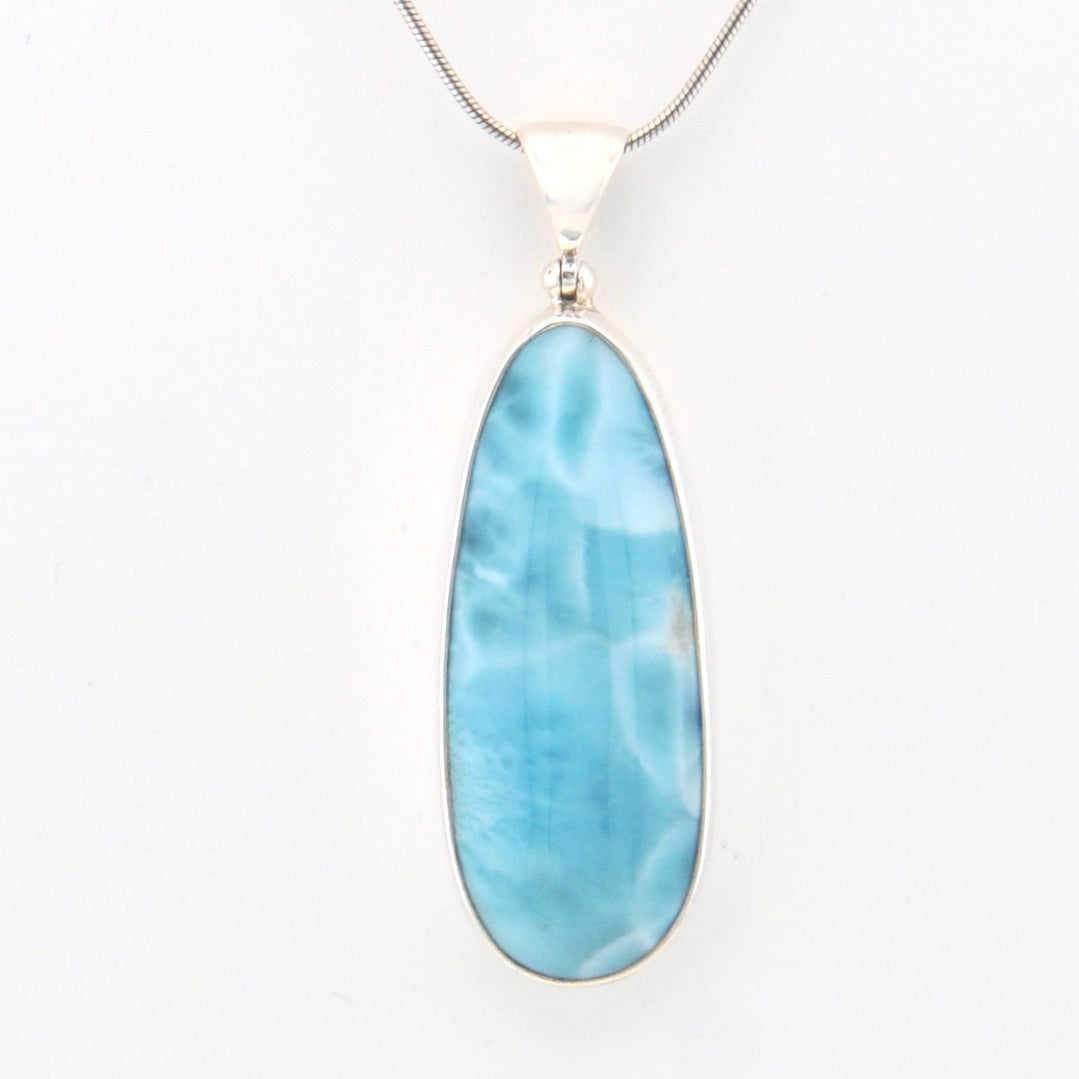 Blue larimar pendant on a white background