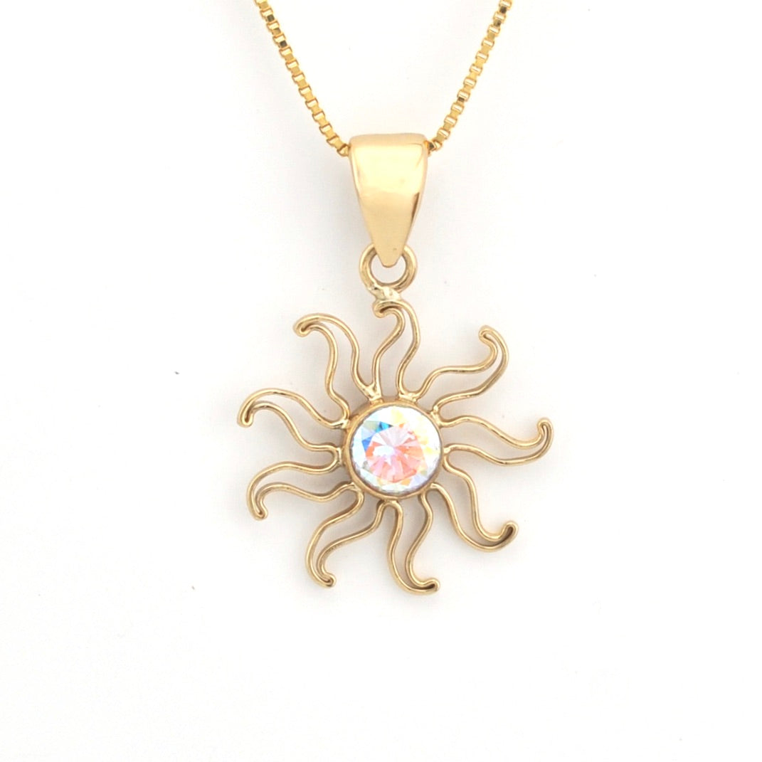 Gold sun-shaped pendant necklace with a colorful center on a white background