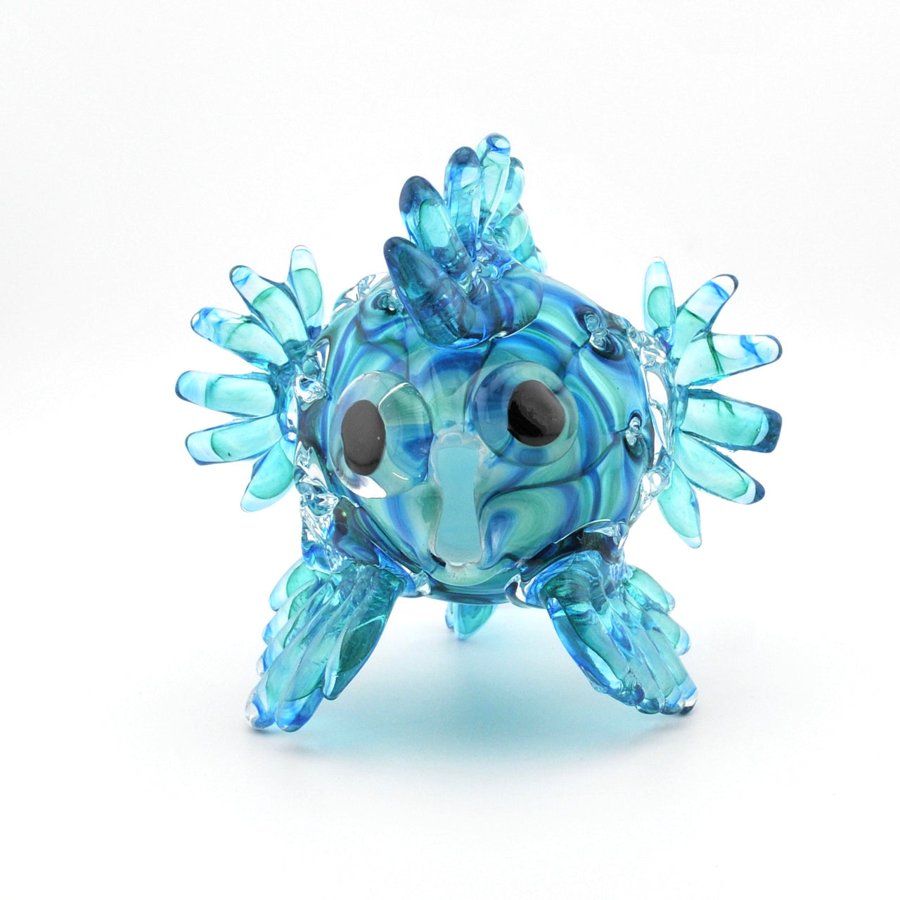 Glass fish figurine with blue and clear patterns on a white background
