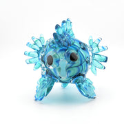 Glass fish figurine with blue and clear patterns on a white background