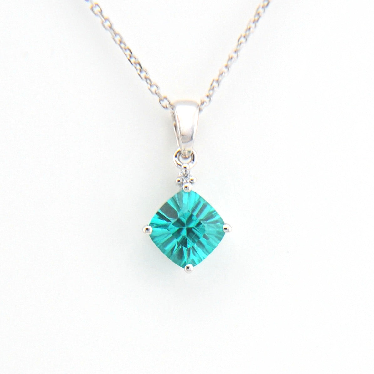 Teal square pendant on a silver chain against a white background
