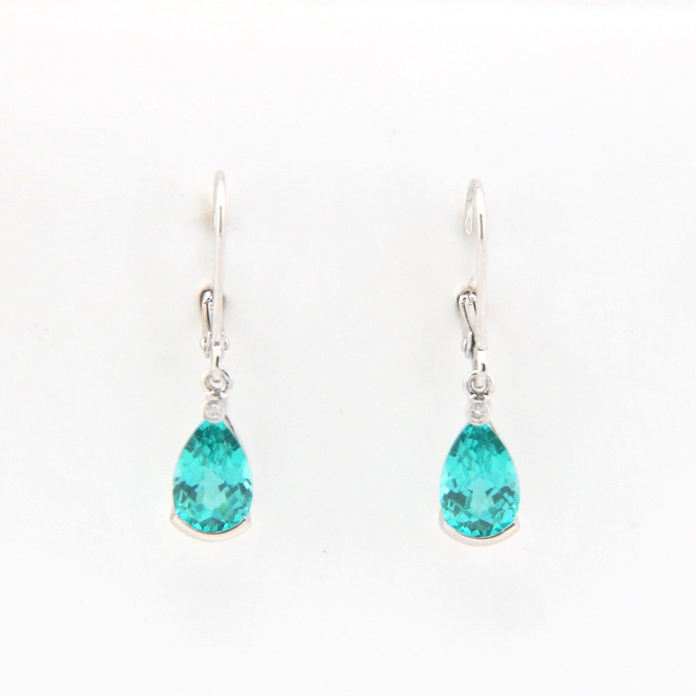 Teardrop-shaped teal earrings on a white background
