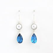 Pair of earrings with blue teardrop stones and pearl-like tops on a white background