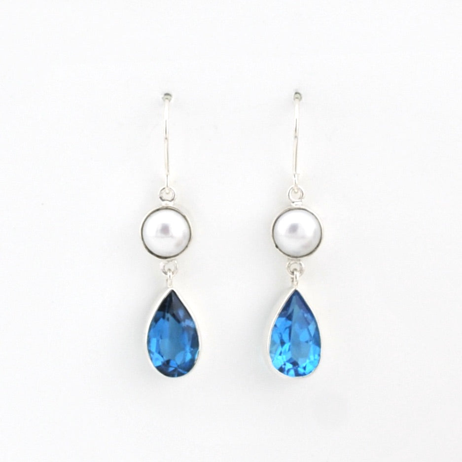 Pair of earrings with blue teardrop stones and pearl-like tops on a white background