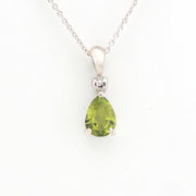 Green teardrop pendant on a silver chain against a white background