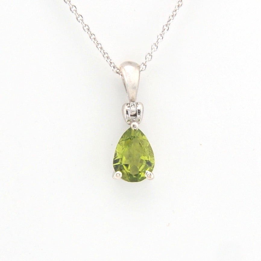 Green teardrop pendant on a silver chain against a white background