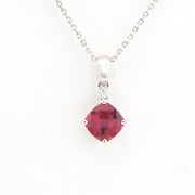 Silver necklace with a red gemstone pendant on a white background