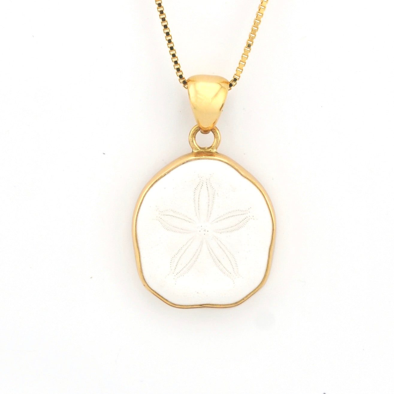 Gold pendant with a white stone on a white background