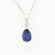 Teardrop-shaped blue gemstone pendant on a white background