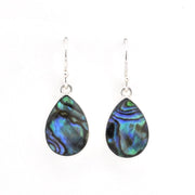 A pair of teardrop-shaped dangle earrings featuring iridescent abalone shell pieces with blue, green, and black swirls, suspended from silver fishhook wires on a plain white background.