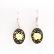 Pair of earrings with gold floral design on black background