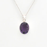 Purple gemstone pendant on a silver chain against a white background
