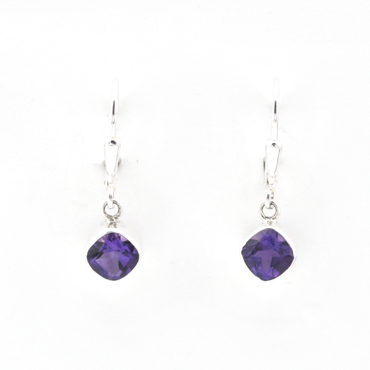 Purple gemstone earrings on silver hooks against a white background