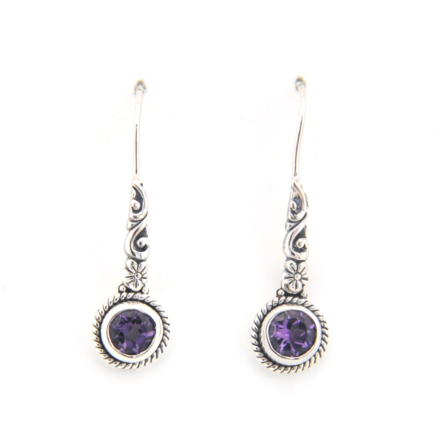 Silver earrings with purple gemstones on a white background