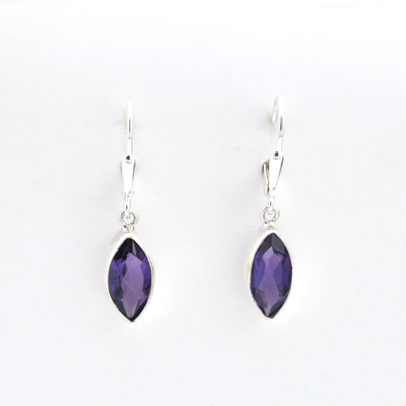 Pair of silver earrings with purple gemstones on a white background