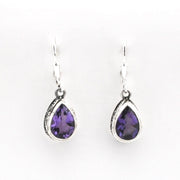 Pair of teardrop-shaped purple gemstone earrings on a white background