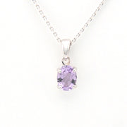 Silver necklace with a purple gemstone pendant on a white background