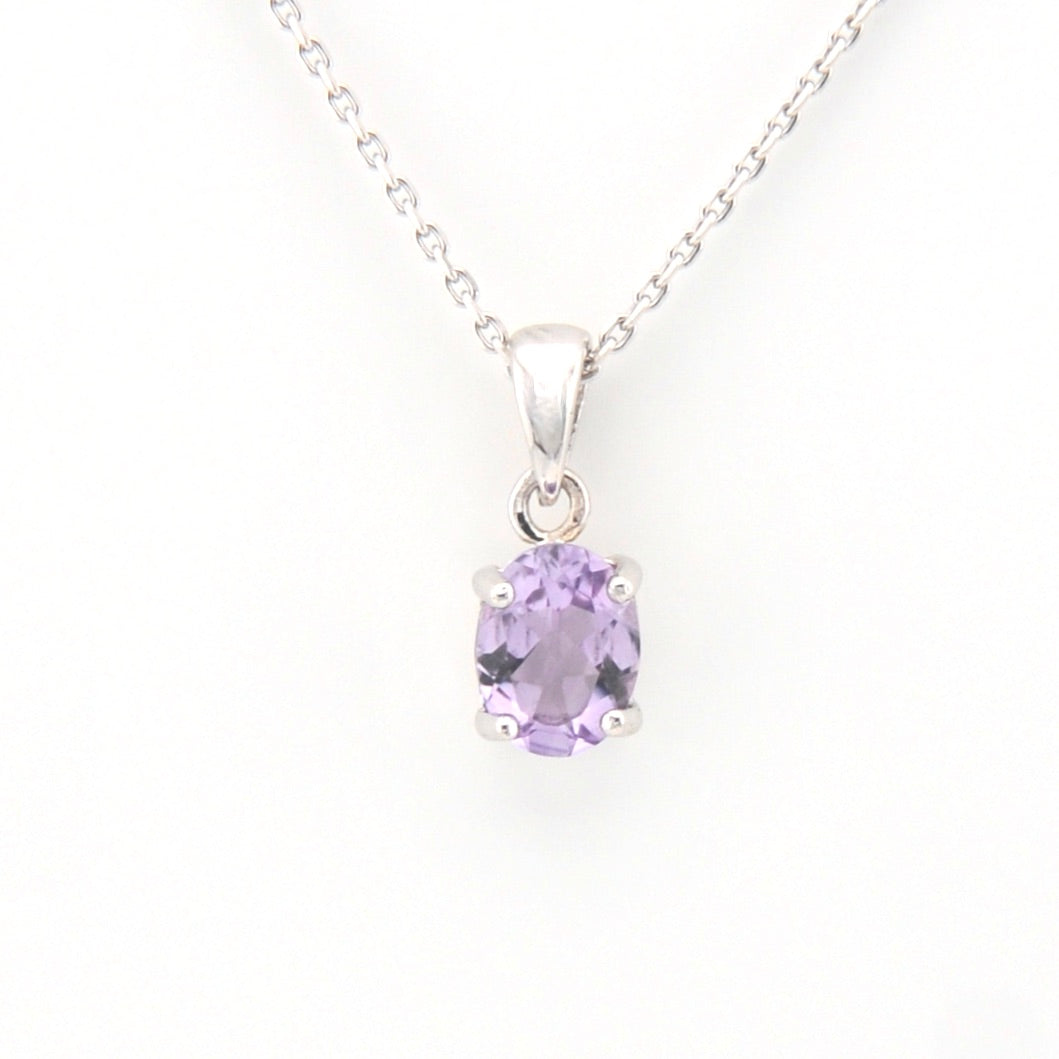 Silver necklace with a purple gemstone pendant on a white background