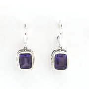 Pair of silver earrings with purple gemstones on a white background