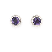 Pair of round purple gemstone earrings with silver rims on a white background