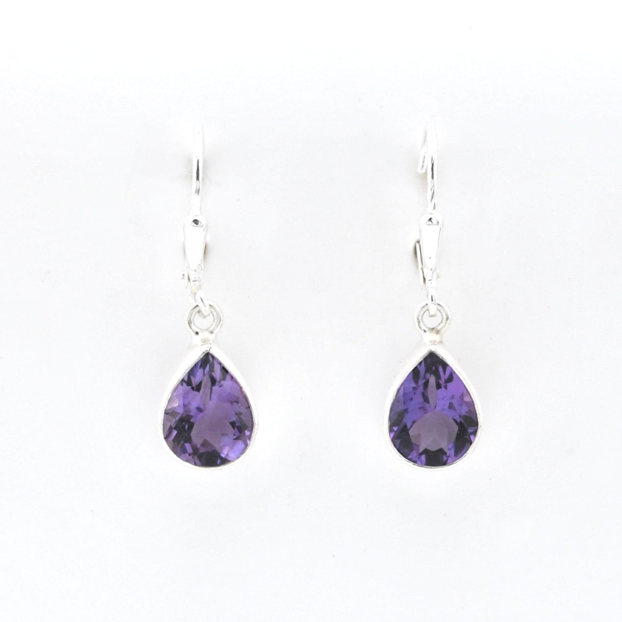 Silver earrings with amethyst teardrop stones on a white background