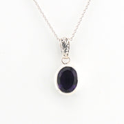 Silver pendant with a purple gemstone on a white background