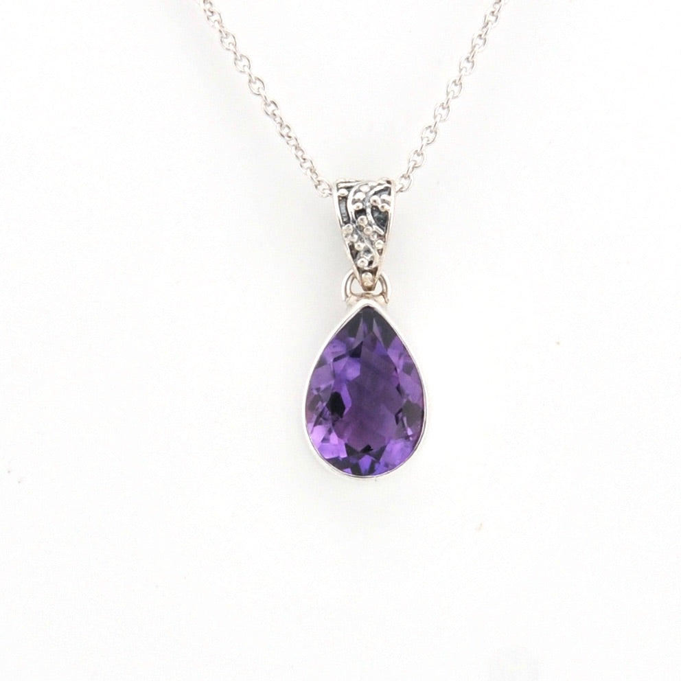Purple teardrop pendant on a silver chain against a white background