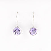 Pair of silver earrings with purple gemstones on a white background