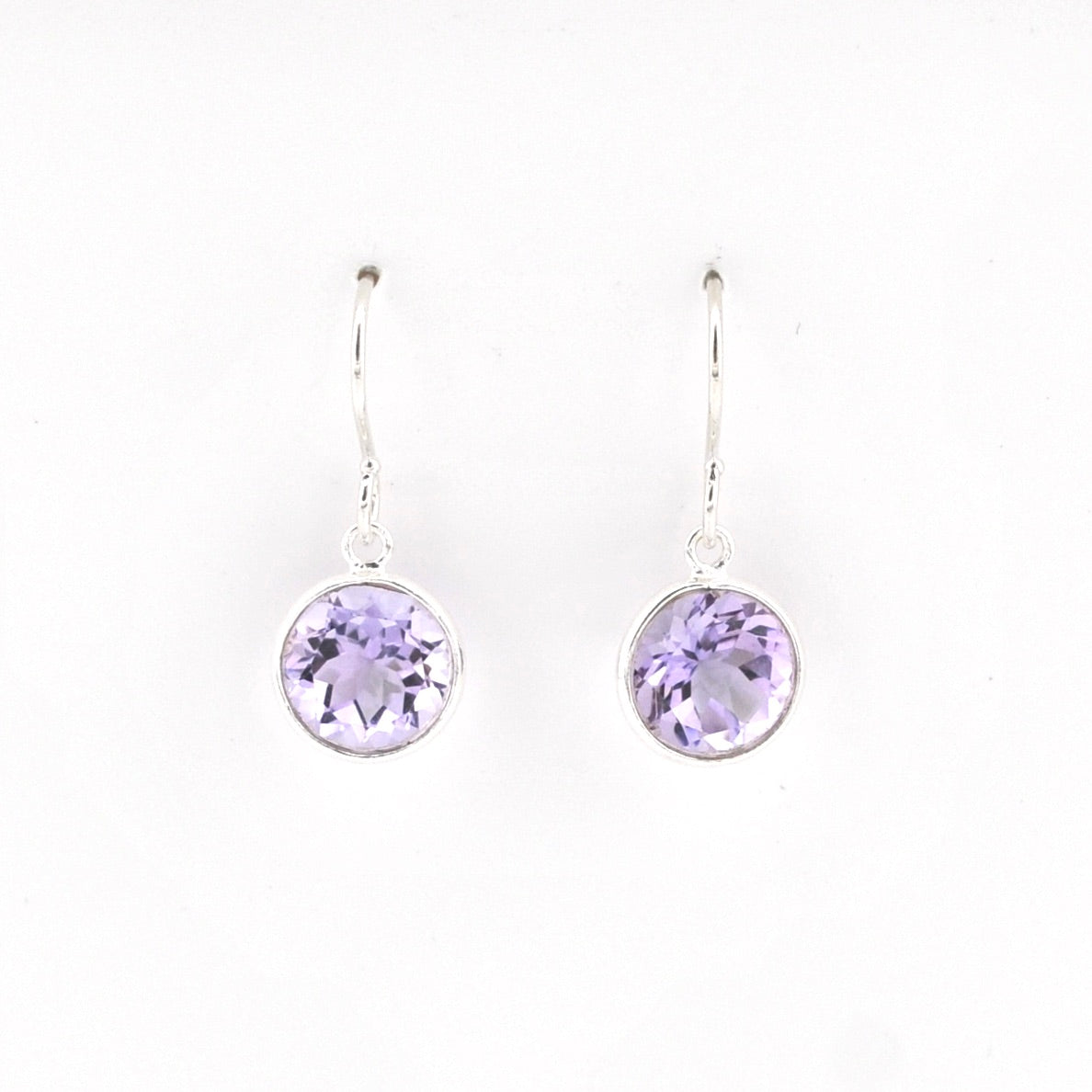 Pair of silver earrings with purple gemstones on a white background