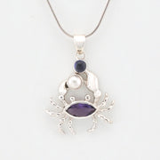 Silver crab pendant with purple and pearl accents on a white background