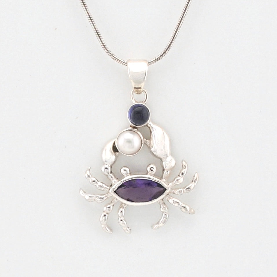 Silver crab pendant with purple and pearl accents on a white background