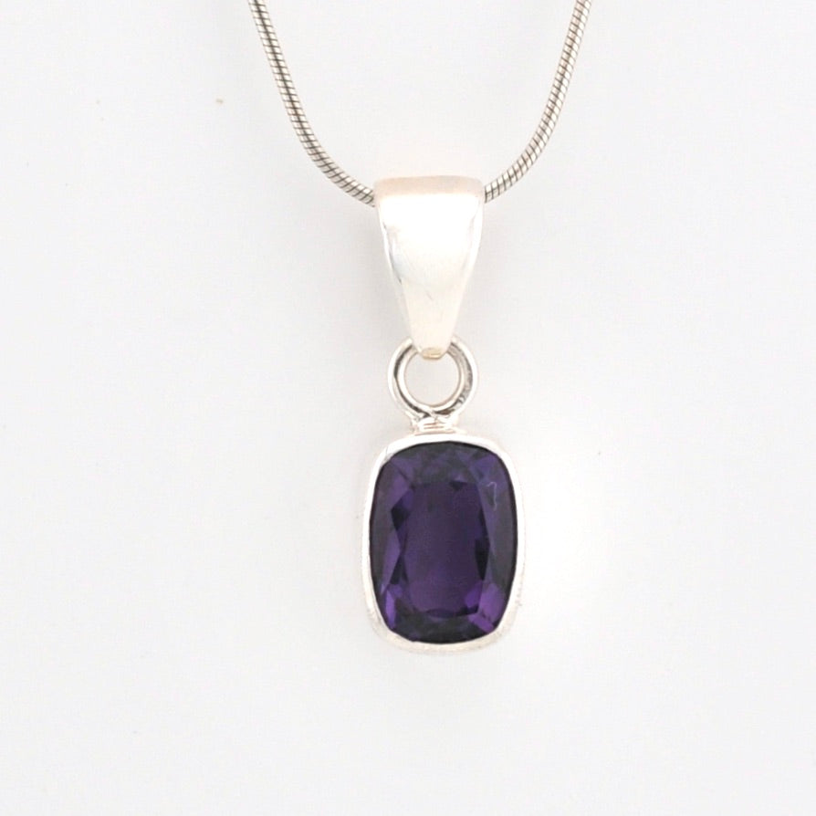 Silver pendant with a purple gemstone on a white background