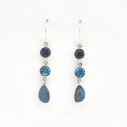Pair of silver earrings with blue gemstones on a white background