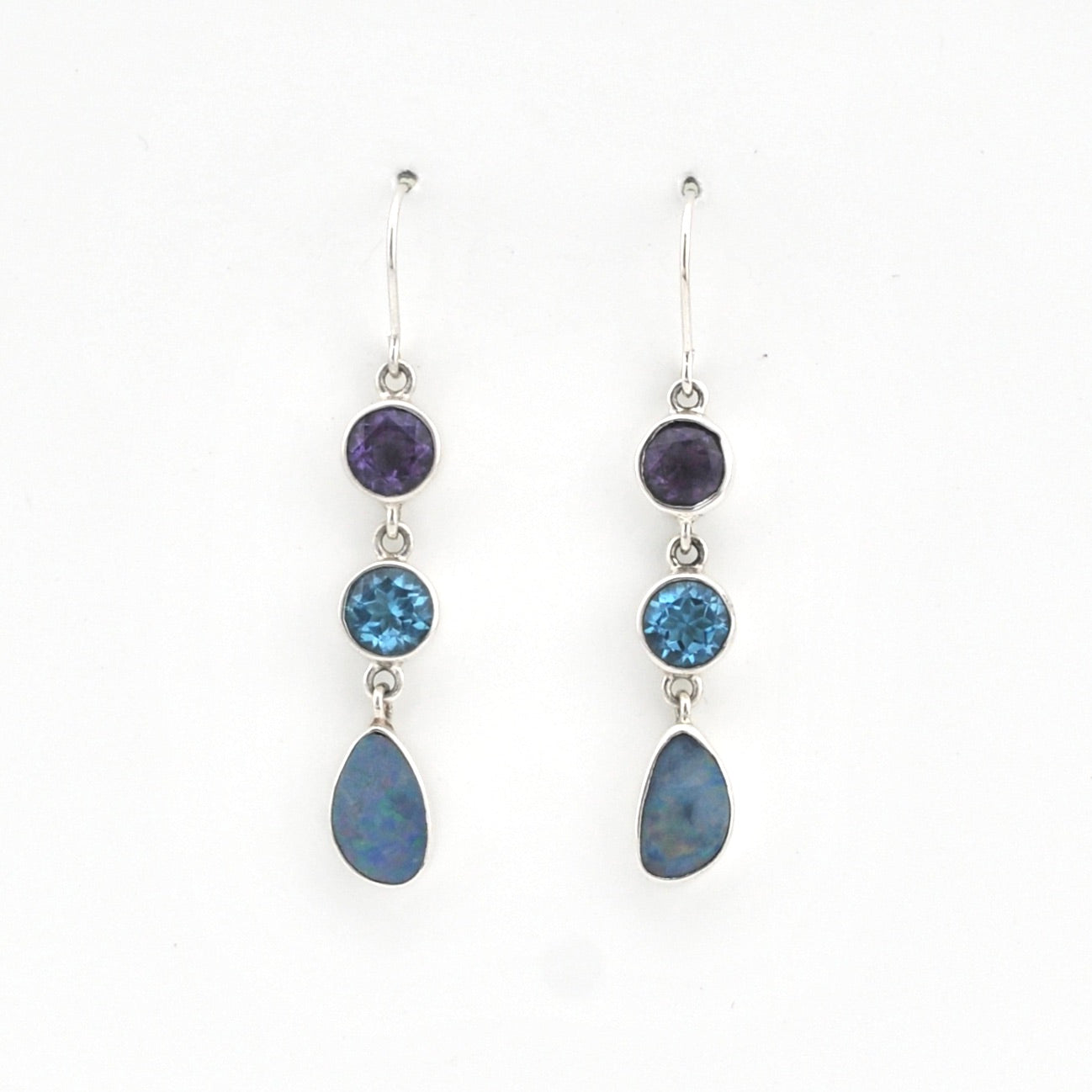 Pair of silver earrings with blue gemstones on a white background