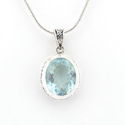 Silver pendant with a blue gemstone on a white background