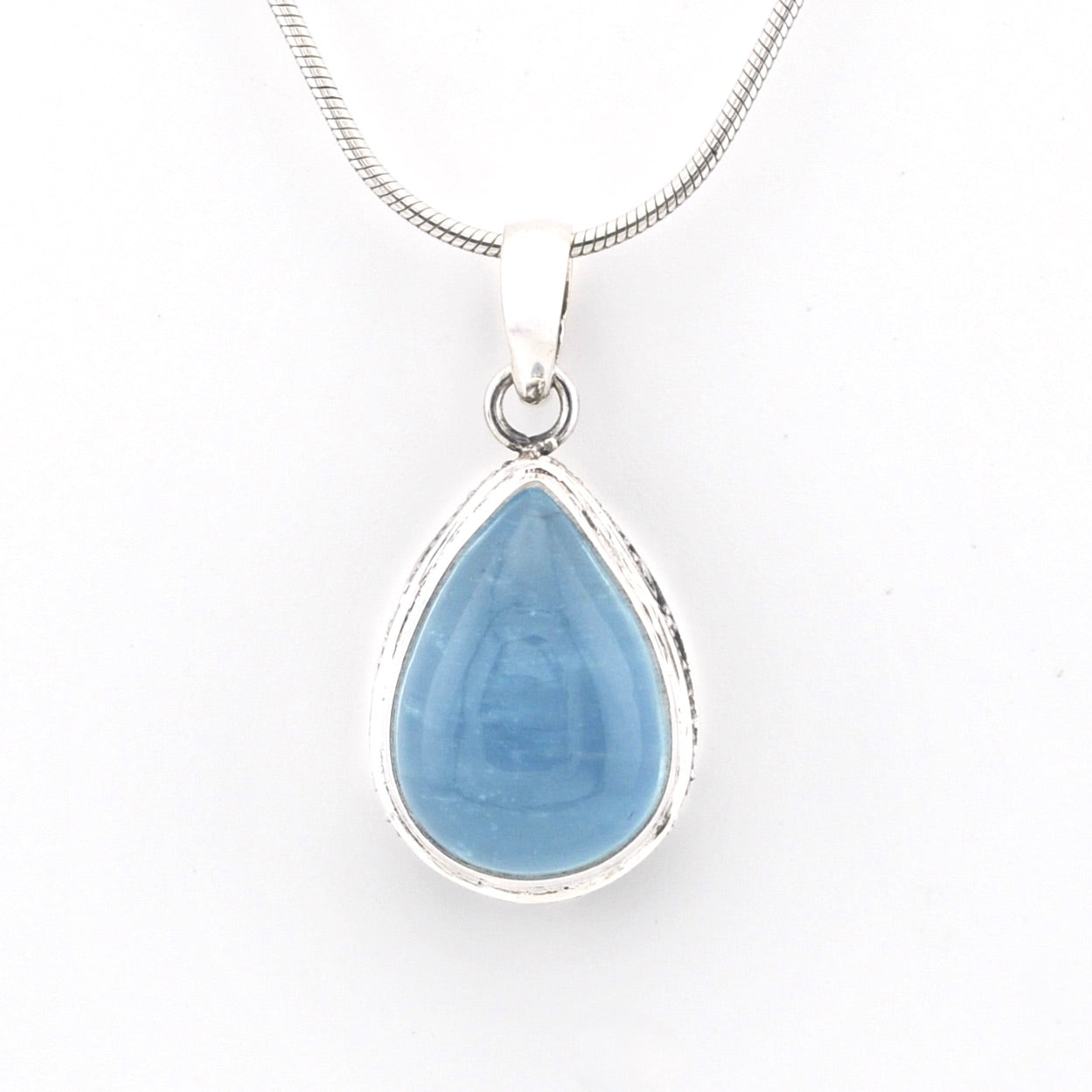 Teardrop-shaped blue pendant on a white background