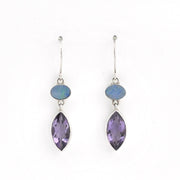 Pair of earrings with marquise-shaped purple stones and smaller round stones on a white background