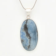 Oval-shaped blue stone pendant on a silver chain against a white background