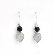 Pair of earrings with black and white stones on a white background