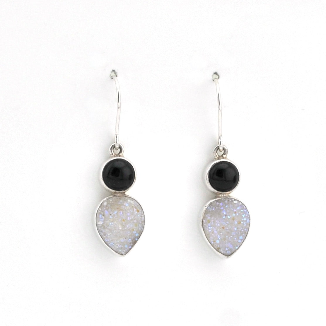 Pair of earrings with black and white stones on a white background