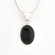 Black oval pendant on a silver chain against a white background