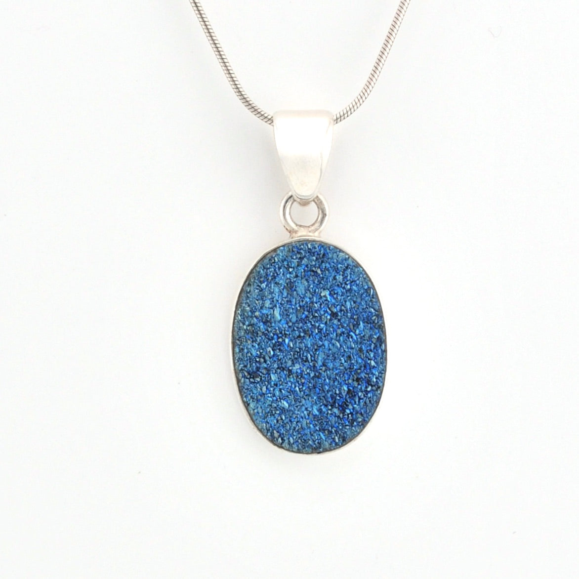Blue druzy pendant on a silver chain against a white background
