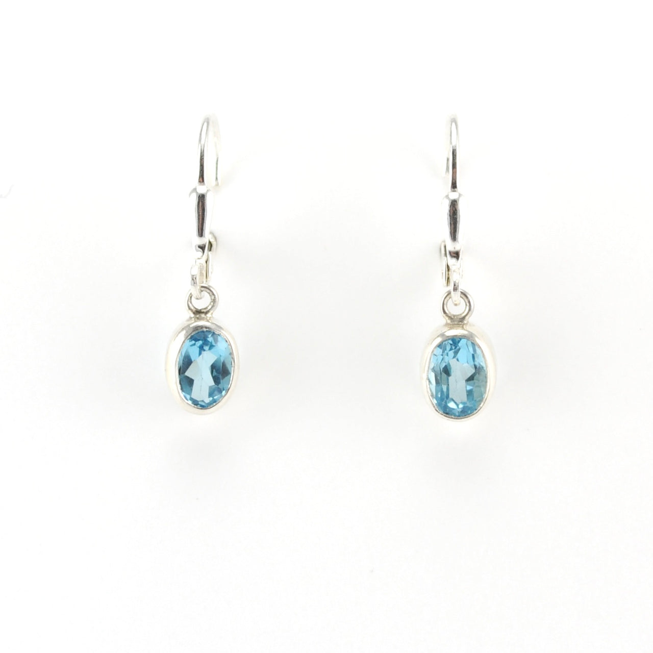 Pair of silver earrings with blue gemstones on a white background