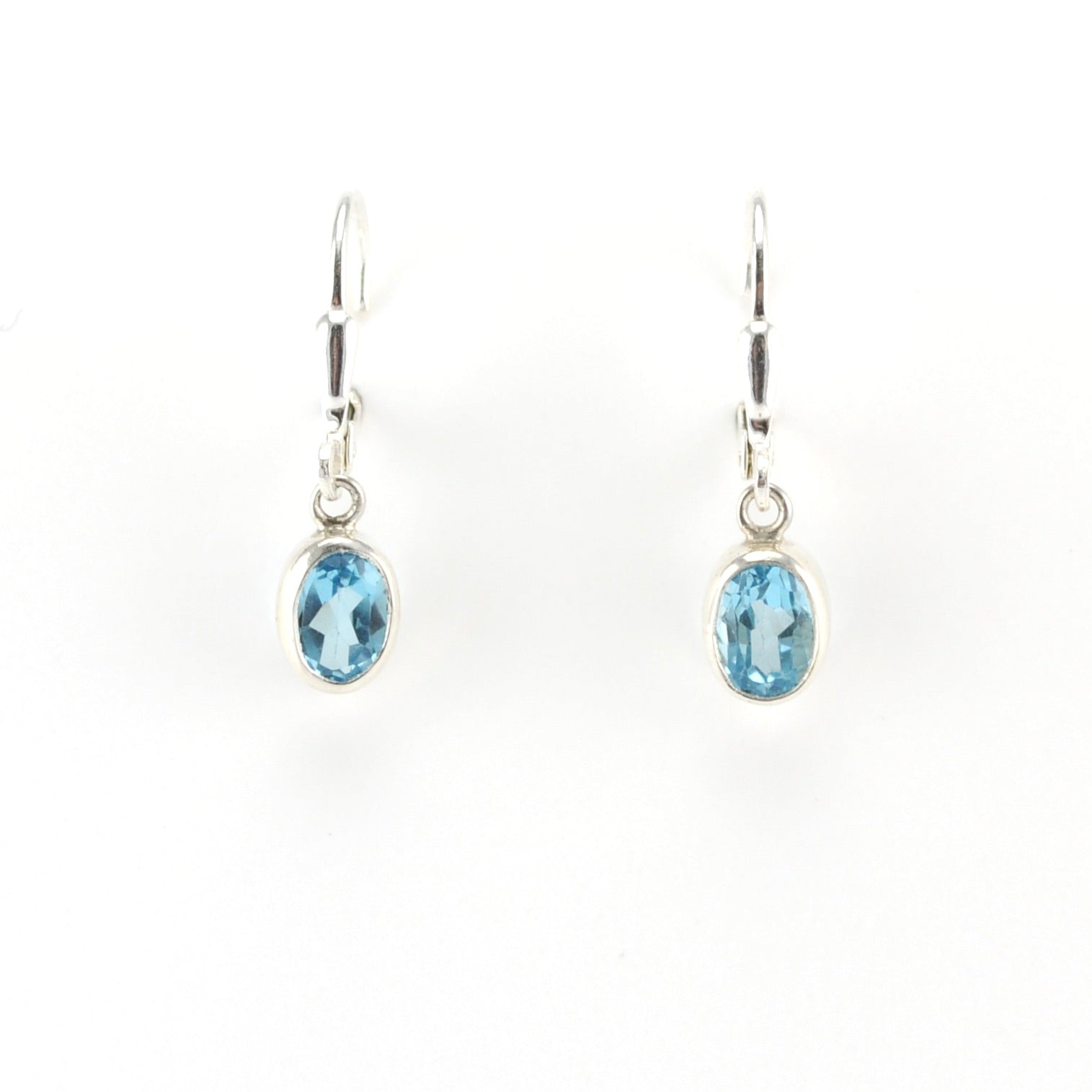 Pair of silver earrings with blue gemstones on a white background