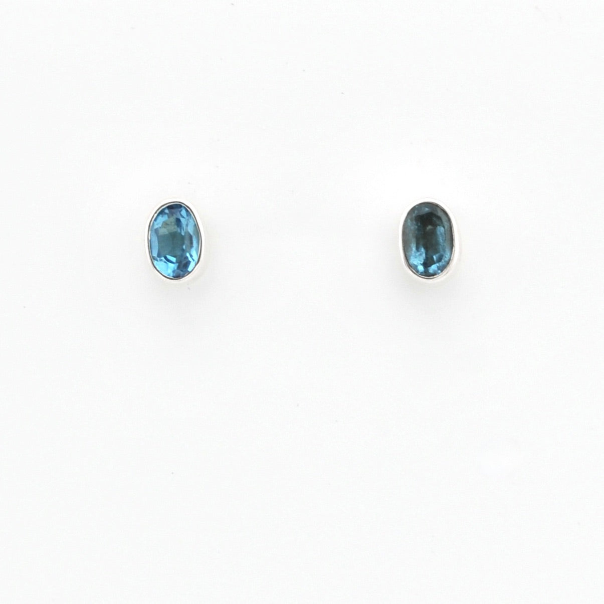 Pair of blue gemstone stud earrings on a white background