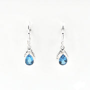 Pair of silver earrings with blue teardrop-shaped gemstones on a white background