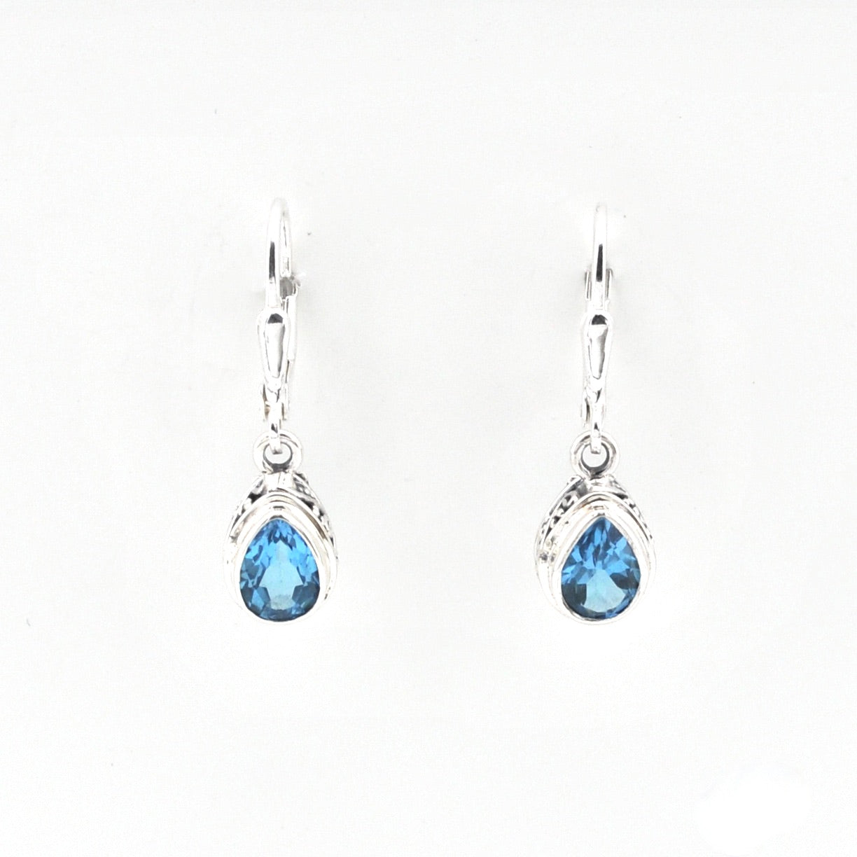 Pair of silver earrings with blue teardrop-shaped gemstones on a white background
