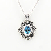 Silver pendant with blue gemstone on a white background
