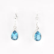 Teardrop-shaped blue gemstone earrings on a white background