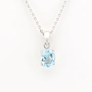 Silver necklace with a blue gemstone pendant on a white background